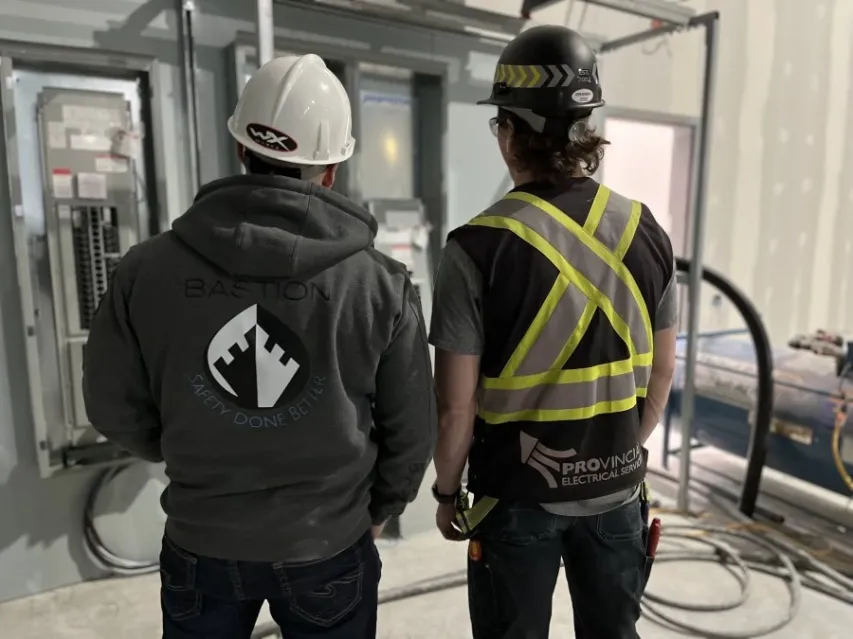 Barry, the CEO of bastion reviews an electrical panel with a employee during a safety consoltation. 