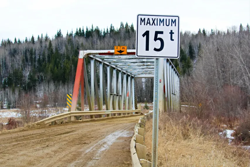 Bridge with posted height limit sign, highlighting the importance of vehicle dimension awareness.