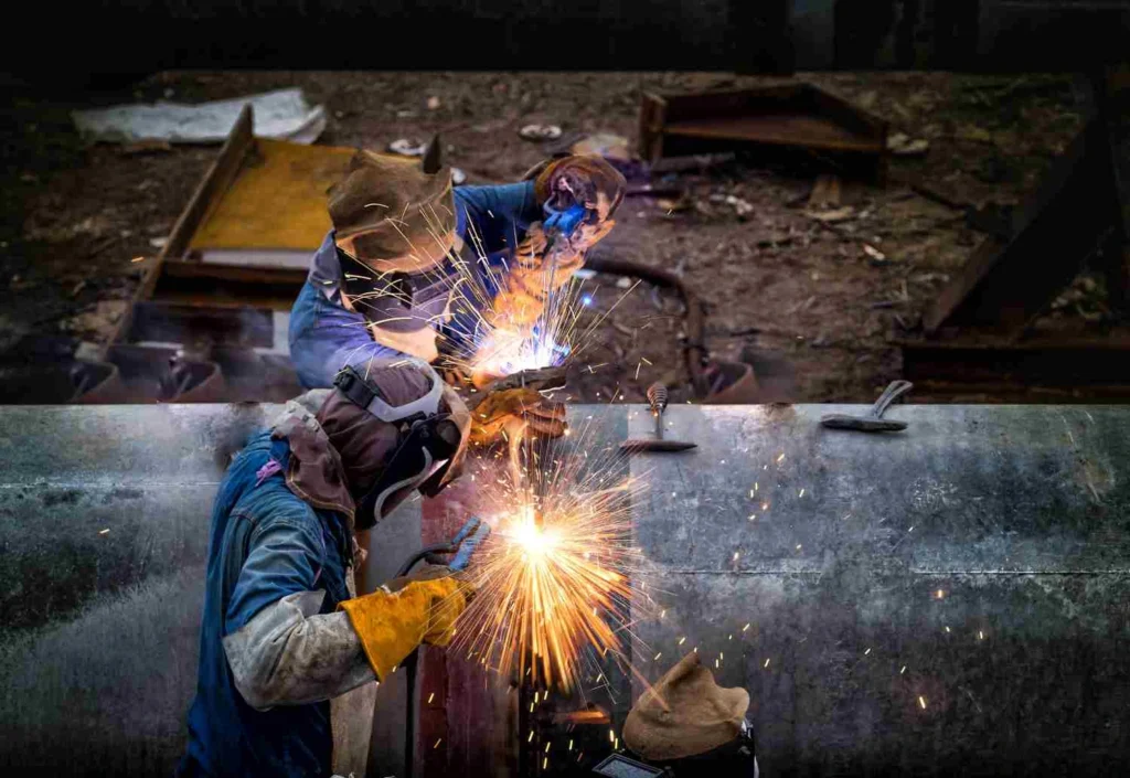Welder is welding big pipe at construction site