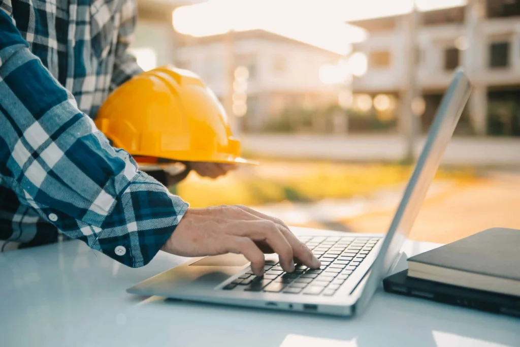 Hands-on laptop at jobsite illustrating how technology enables real-time safety training and certification tracking.