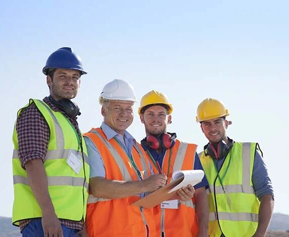 Businessman and workers smiling on site