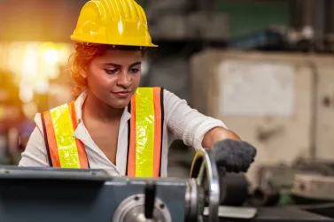 - BIS Safety Software Girl teen worker african american working labor in industry factory with heavy steel machine.