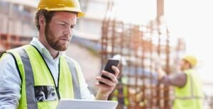 - BIS Safety Software Construction worker digital tablet texting cell phone at constru