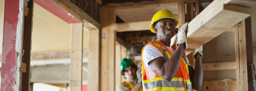 - BIS Safety Software Tradesmen carrying lumber at construction site