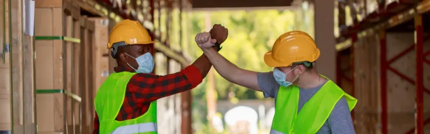 - BIS Safety Software playful diversity warehouse workers playing dancing during break time at storehouse, Caucasian and black African man wearing face mask, new normal after pandemic crisis at work.