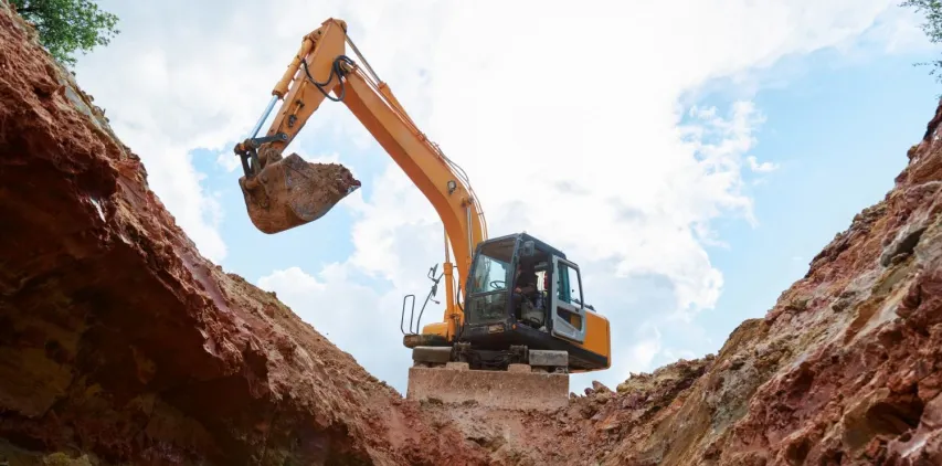 - BIS Safety Software Excavator digging a trench. Work on the construction site.