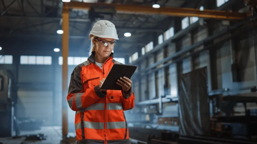 - BIS Safety Software Professional Heavy Industry Engineer Worker Wearing Safety Uniform and Hard Hat, Using Tablet Computer. Serious Successful Female Industrial Specialist Walking in a Metal Manufacture Warehouse.