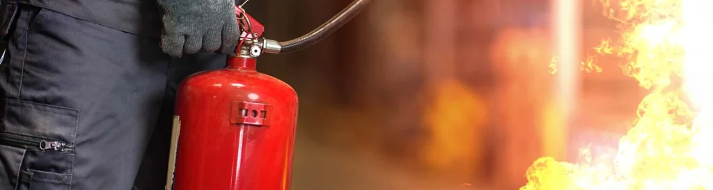 Man using fire extinguisher fighting fire closeup
