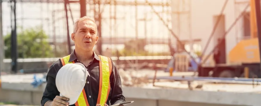 - BIS Safety Software Tired fatigued engineer worker constructor working in construction site.