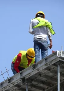 Construction workers working at height without wearing proper sa