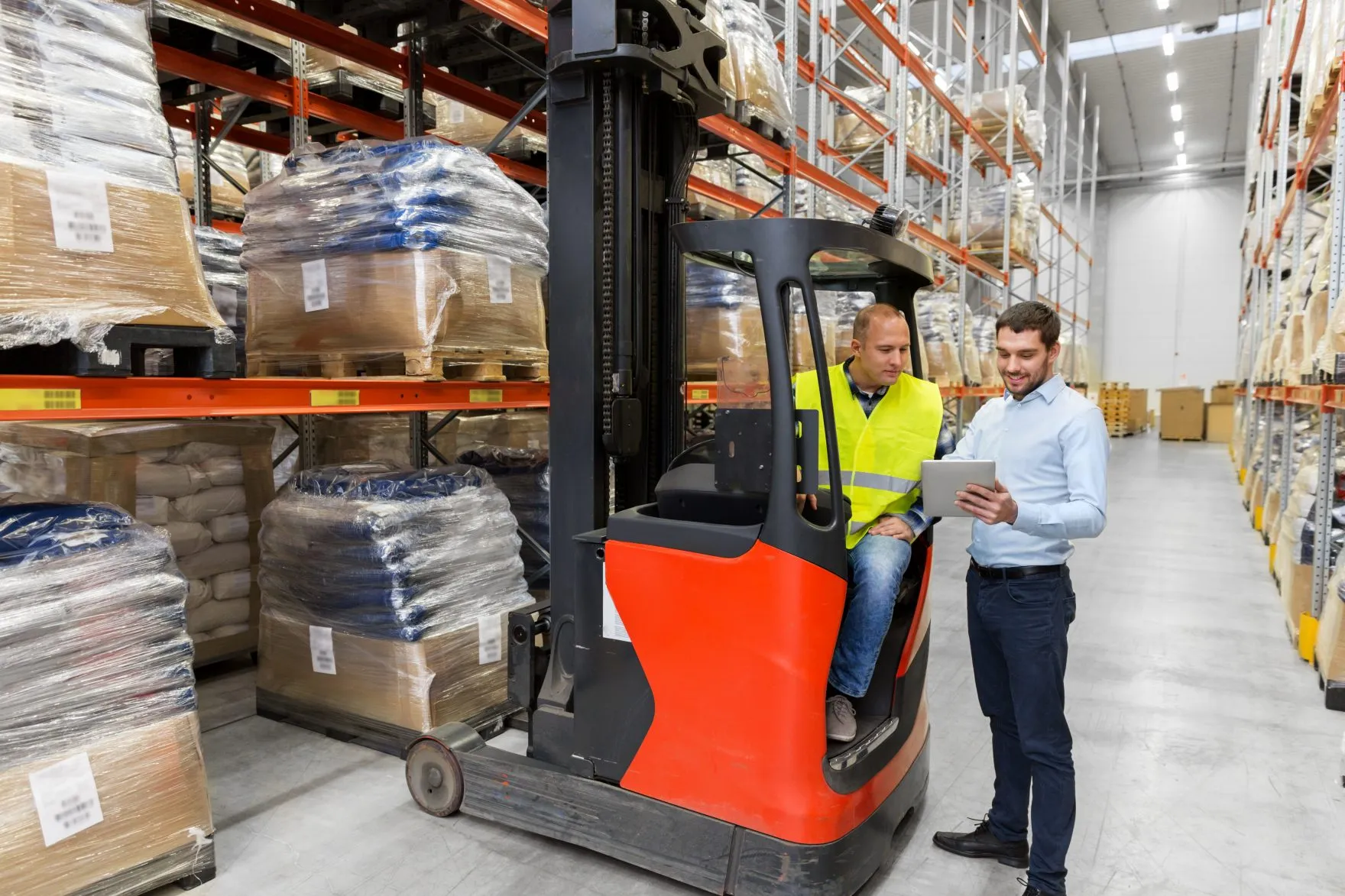men with tablet pc and forklift at warehouse