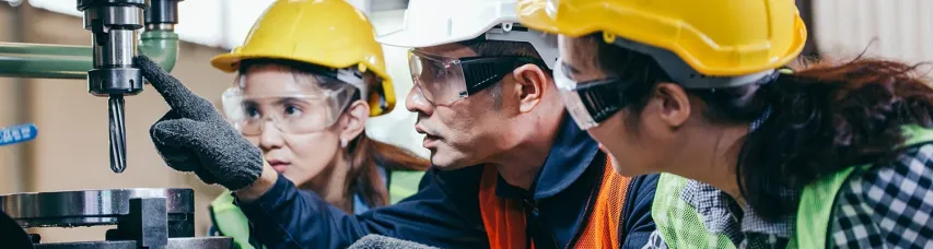 3 Workers Wearing PPE's and Discussing Machine Safety at a Workplace 