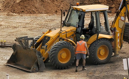 a man getting close to an excavator on a work site
