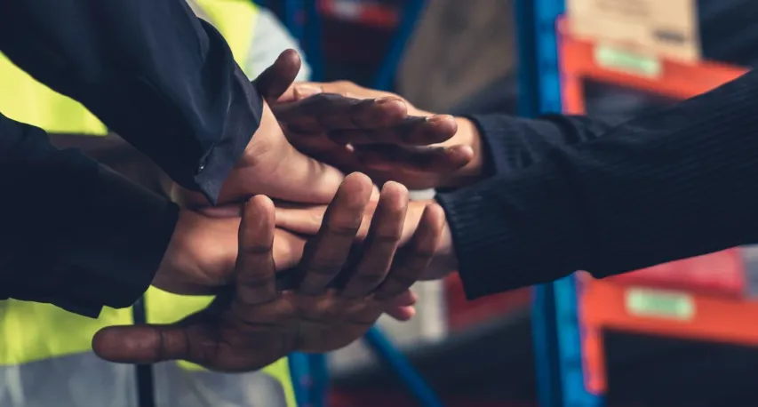 - BIS Safety Software Factory workers stacking hands together in warehouse or storehouse . Logistics , supply chain and warehouse business concept .