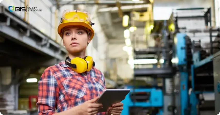 Female engineer inspecting machinery in a factory.