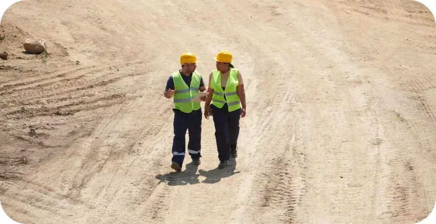 Two construction workers reviewing a construction site.