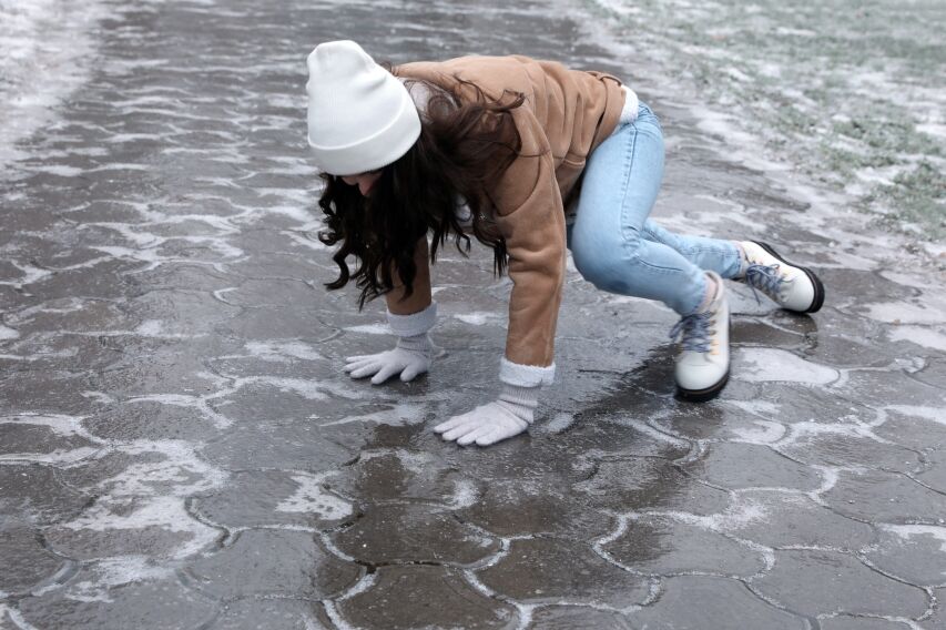 Same‑level fall on a slick surface caused by hidden ice during winter conditions.