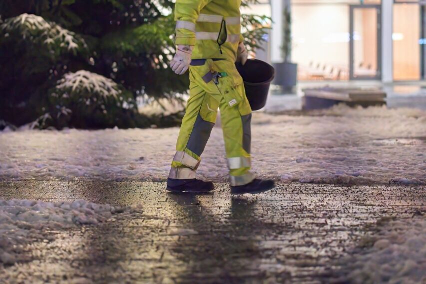 Applying de‑icer to walkways to control moisture, boost traction, and stop winter STFL incidents