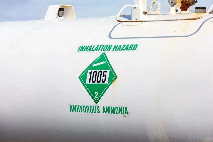 Close view of NH₃ tank showing UN 1005 label and “Inhalation Hazard” warning for anhydrous ammonia.