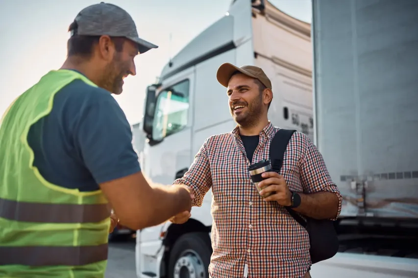 Truck driver and inspector discussing weight and dimension compliance at a checkpoint.
