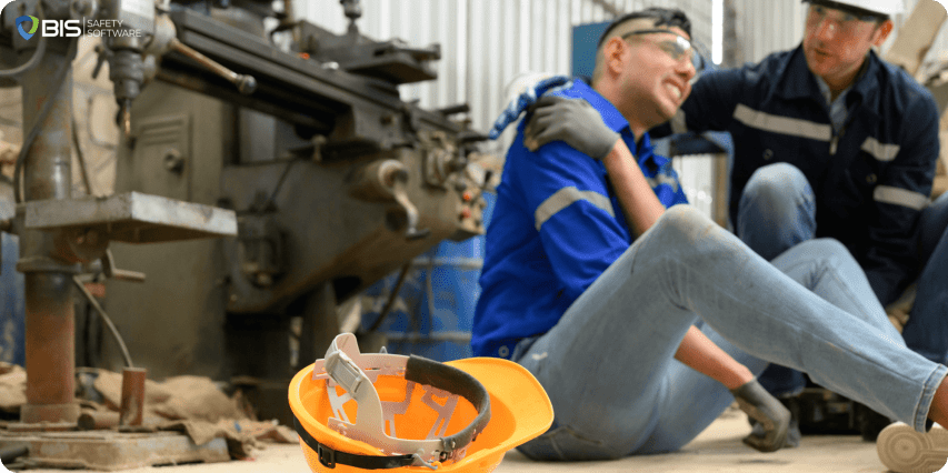 Injured worker sits on floor in pain, supported by a coworker.