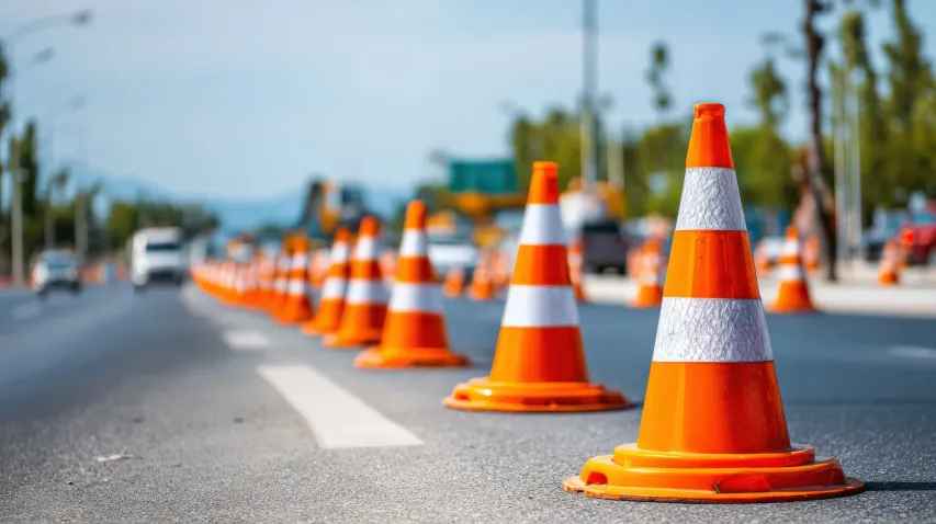 Electronic variable message signs warning drivers to expect delays approaching a work zone at sunset.