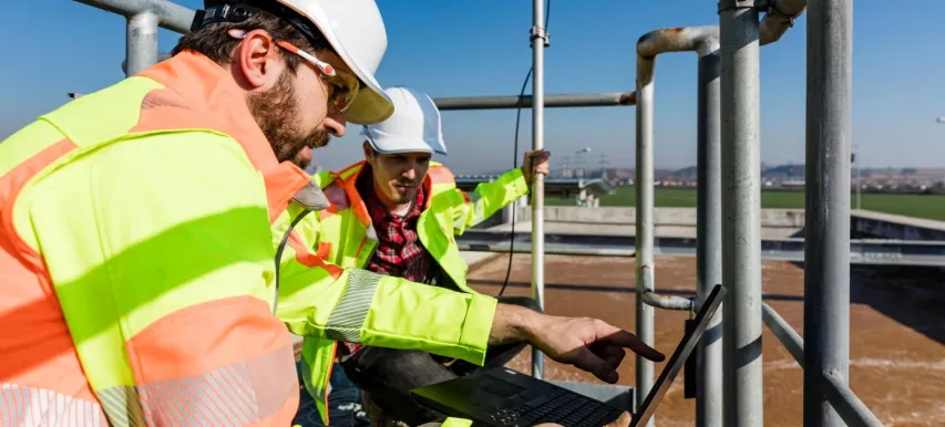 - BIS Safety Software Engineers working on water treatment plant with laptop and measuring sensors