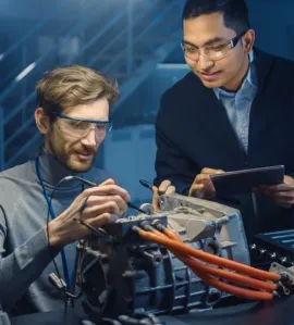 - BIS Safety Software Two Professional Automotive Engineers with a Tablet Computer and Inspection Tools are Having a Conversation While Testing an Electric Engine in a High Tech Laboratory with a Concept Car Chassis.