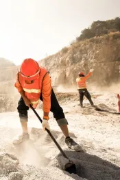 Miners working with mining tool in dusty and baking hot, mining and summer hot sun in the backgrounds. Hard work concept. Noise, Grain.
