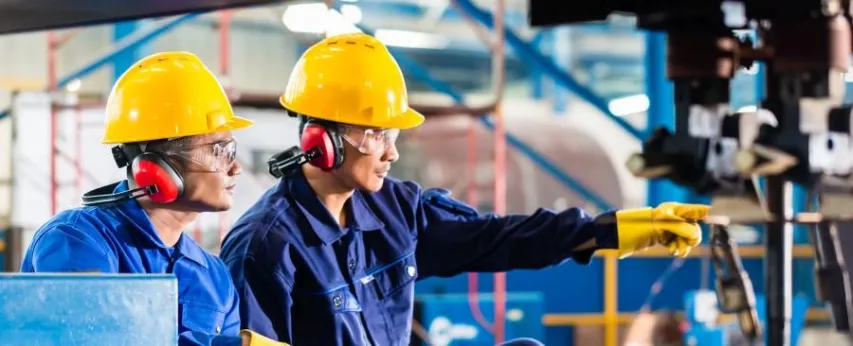 - BIS Safety Software Workers in Asian factory at industrial metal cutting torch machine pointing out things that require preventive action.